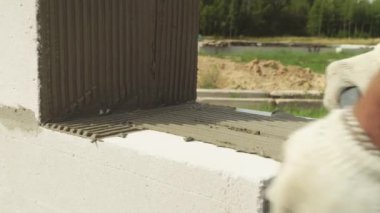 Yapıştırıcı bir sonraki blok koymak için spatula ile yapıştırıcı bileşimi veya çözeltisi uygular.