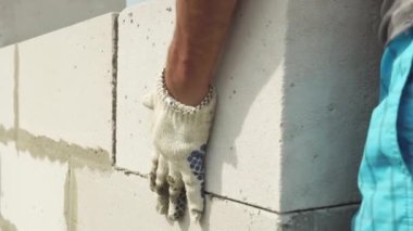 Duvarcı, inşaatçı esnek bir ip kullanarak tuğla ya da bloklar örer.