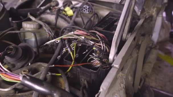 Atelier de réparation de voiture, ou de démontage de voiture. Sur l'ascenseur pend le moteur sorti de la voiture. — Video