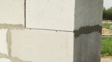 İnşaatçı, duvar yapısına spatula ile yapıştırıcı bileşimi veya çözeltisi uygular.