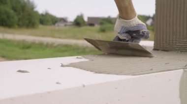 Yapıştırıcı bir sonraki blok koymak için spatula ile yapıştırıcı bileşimi veya çözeltisi uygular.