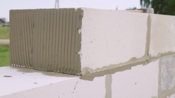 砖匠从块上铺墙，在室外用铲子铺油灰. — 图库视频影像