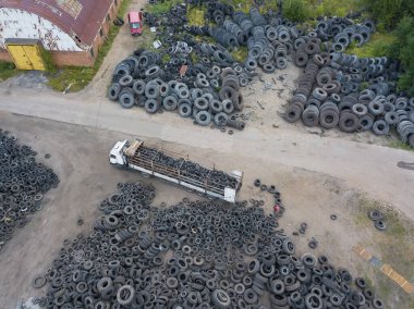 Depoda çok sayıda kullanılmış lastiğin insansız hava aracının görüntüsü. Kamyon depoya geri dönüşüm için eski lastikleri getirdi.