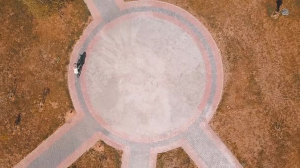 Top view of a bicycle woman riding a bicycle on a circular road in a city park. — Stock Video