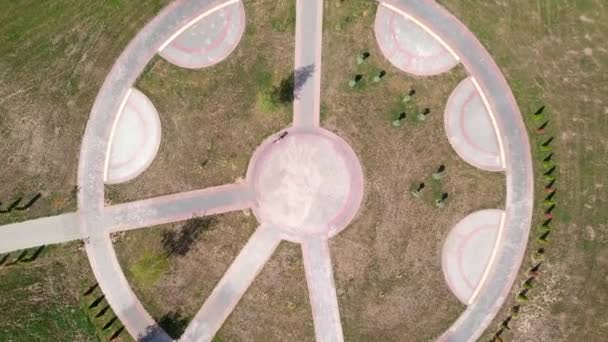 Vista dall'alto di una donna in bicicletta in bicicletta su una strada circolare in un parco cittadino. — Video Stock