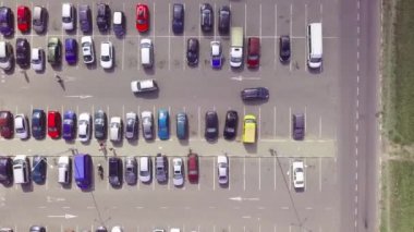 Alışveriş merkezinin yanındaki otoparkta park halindeki arabaların kuş bakışı görüntüsü..