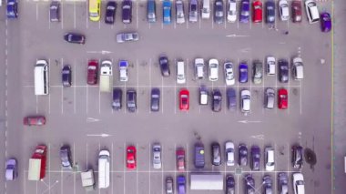 Alışveriş merkezinin yanındaki otoparkta park halindeki arabaların kuş bakışı görüntüsü..