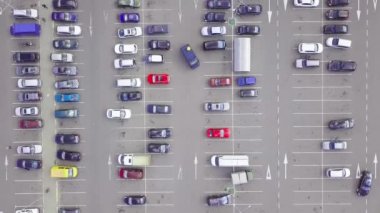 Alışveriş merkezinin yanındaki otoparkta park halindeki arabaların kuş bakışı görüntüsü..