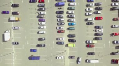 Alışveriş merkezinin yanındaki otoparkta park halindeki arabaların kuş bakışı görüntüsü..