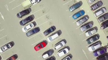 Alışveriş merkezinin yanındaki otoparkta park halindeki arabaların kuş bakışı görüntüsü..