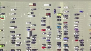 Alışveriş merkezinin yanındaki otoparkta park halindeki arabaların kuş bakışı görüntüsü..