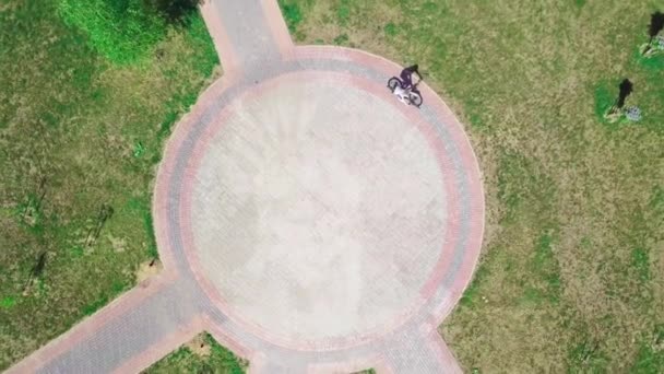 Top kilátás egy biciklis nő biciklizés egy körkörös úton egy városi parkban. — Stock videók