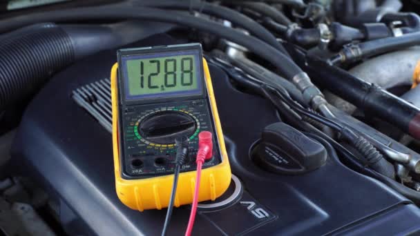 Spanning van de startaccu van de auto wordt gemeten door multimeter. spanning 13 volt, — Stockvideo