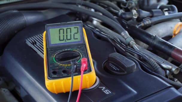 Spanning van de startaccu van de auto wordt gemeten door multimeter. spanning 13 volt, — Stockvideo