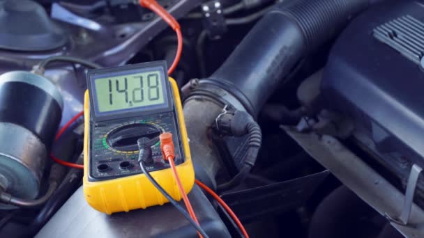Voltaje de la batería de arranque del coche se mide por multímetro. voltaje 14 voltios, — Vídeos de Stock