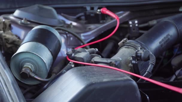 Die Spannung der Starterbatterie eines Autos wird per Multimeter gemessen. Spannung 14 Volt, — Stockvideo