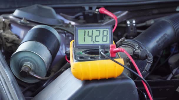 Spanning van de startaccu van de auto wordt gemeten door multimeter. spanning 14 volt, — Stockvideo