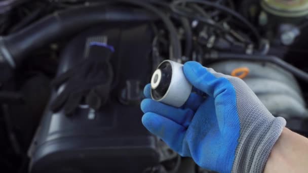 Master i handske håller spaken tyst block i handen mot bakgrund motor. — Stockvideo