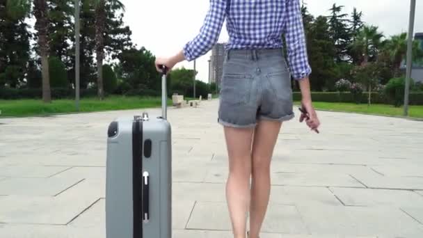 Rear view of a female traveler, she walks through the southern city — Stock Video