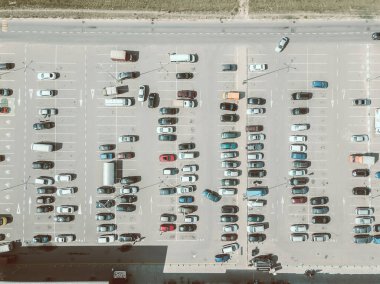 Güneşli bir yaz gününde büyük bir otoparkın insansız hava aracı görüntüsü, yatay araba parkı. Sinematik yaz tarzında boyama fotoğrafları.