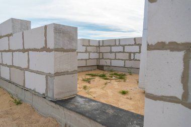 Havalandırmalı beton bloklardan yapılmış bir evin inşaat alanı, evin duvarları. Bir ev inşa etme kavramı