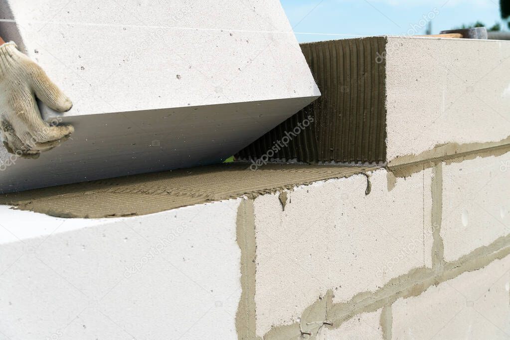 Builder makes a concrete wall with cement blocks on the construction site of a house. Concept of building a house