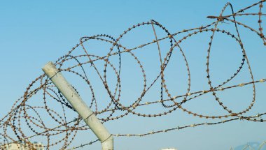 Gün batımında havaalanı çevresinde dikenli teller var.