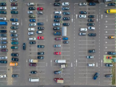 Güneşli bir yaz gününde, büyük bir otoparkın insansız hava aracı görüntüsü.