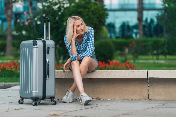 Sad Young Blonde Woman Shorts Shirt Sitting Suitcase Bench Background — Stock Photo, Image
