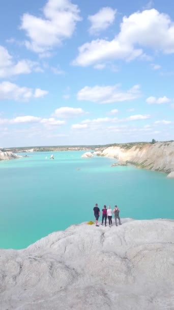 Zwei Mädchen und zwei Männer stehen auf dem Gipfel eines Berges in Kalksteinbrüchen — Stockvideo