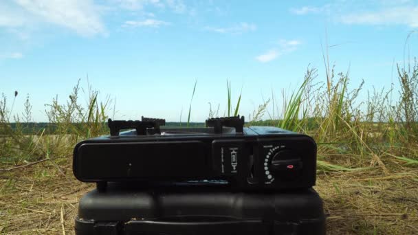 Női kéz, közelkép, hogy egy vízforraló egy gázégő fűtés víz a természetben — Stock videók