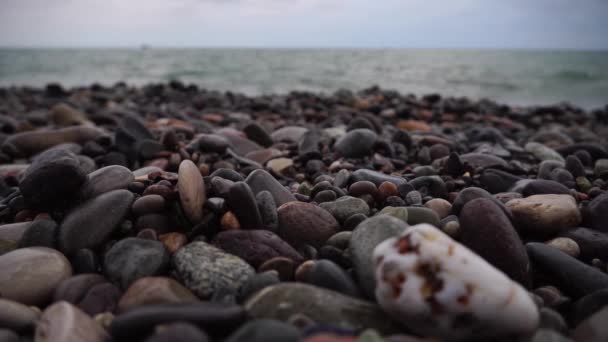 Close-up de uma praia de pedra à noite. O mar ao pôr do sol. — Vídeo de Stock