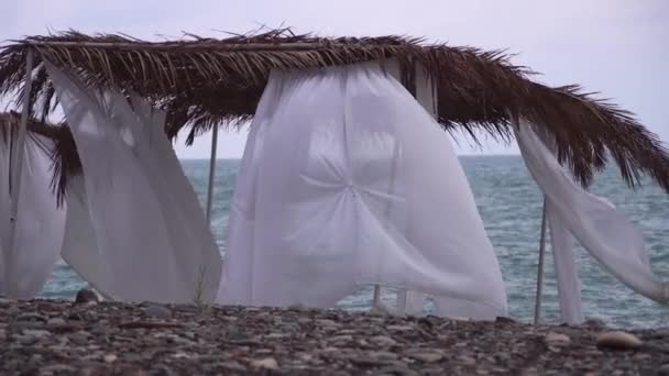 Deniz kıyısındaki kumlu bir sahilde rüzgar kesici çadır.. — Stok video