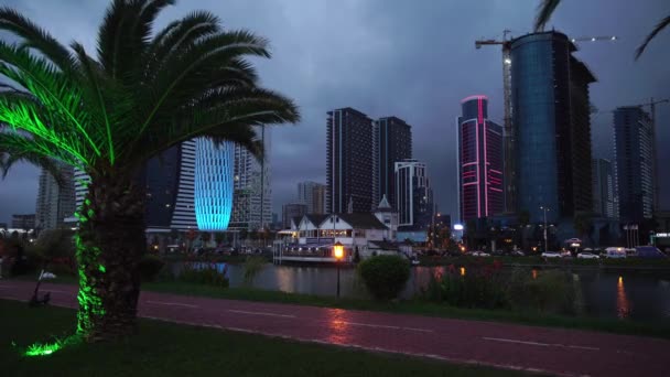 Caminata nocturna en Batumi. Coloridos edificios modernos de hotel, iluminados por ledes, — Vídeo de stock