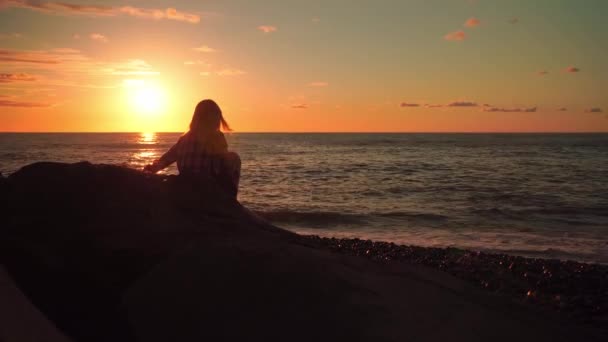 La silueta de una esbelta mujer en la playa en una hermosa puesta de sol, — Vídeos de Stock