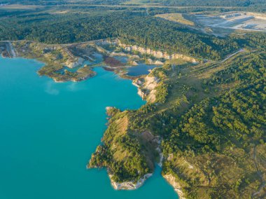 Krichev yakınlarındaki Belarus 'ta yapay bir tebeşir ocağı gölü görüntüsü. Turkuaz su, yaz mevsiminde, açık bir çukurda. Tebeşirin çıkarılması sırasında insan yapımı dağlar oluştu..