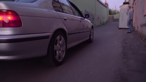 Close-up de um carro bmw se movendo ao longo de uma rua abandonada — Vídeo de Stock