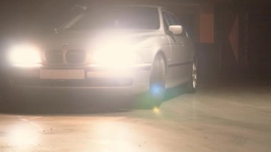 BMW 5 serisi 530d e39 gümüş rengi, bir yeraltı otoparkında sürüyor.