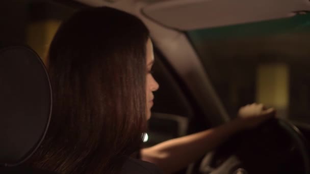 Жінка блимає очима, дивиться на камеру. Вона сидить у машині за кермом . — стокове відео