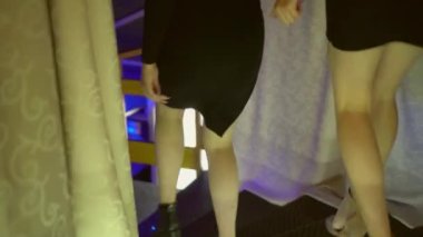 Gece kulübünde masadan kalkıp merdivenlerden inen iki kadın. Bacaklar yakın plan..