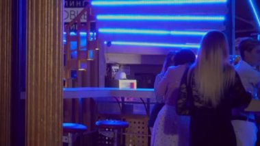 Kırmızı elbiseli, uzun saçlı güzel, esmer kadın bara yaklaşıyor ve kokteyl ısmarlıyor.