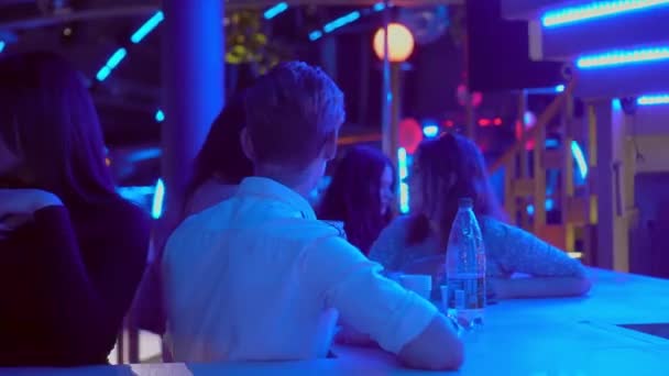 In un nightclub, un grande gruppo di persone si siede al bar e si diverte. — Video Stock