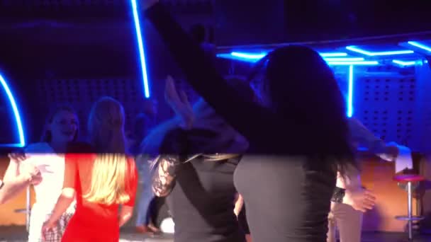 Jonge jongens en meisjes dansen in een club. Menigten mensen dansen in een moderne club — Stockvideo