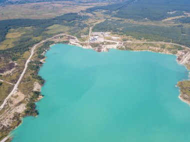 Krichev yakınlarındaki Belarus 'ta yapay bir tebeşir ocağı gölü görüntüsü. Turkuaz su, yaz mevsiminde, açık bir çukurda. Tebeşirin çıkarılması sırasında insan yapımı dağlar oluştu..