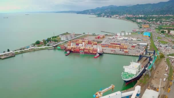 Schip zicht van een drone. Uitladen van containers door een bemanning en een kraan in de haven — Stockvideo