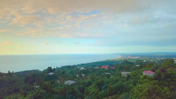 Movimento de drone ao longo da costa do mar e da floresta verde, uma aldeia ou aldeia — Vídeo de Stock
