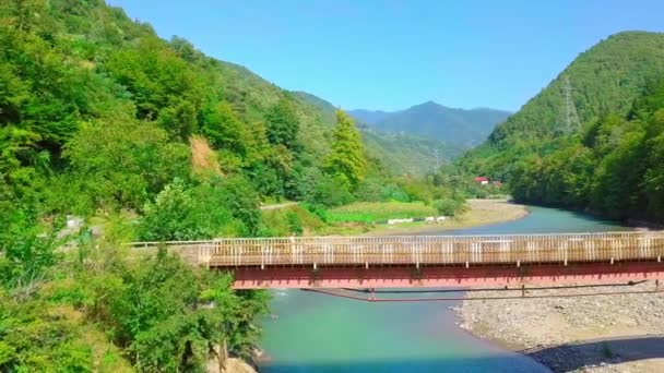 Vista aerea laterale di un uomo che attraversa un ponte in Georgia sul fiume Chorokhi, — Video Stock