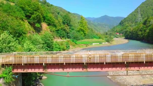 Luftfoto af en mand, der krydser en bro i Georgien over Chorokhi-floden, – Stock-video
