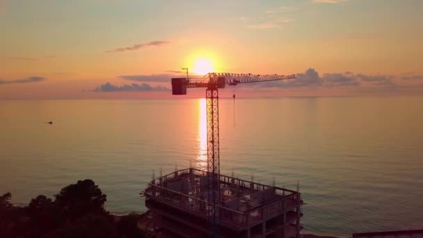 Kraan bij zonsondergang vanuit vogelperspectief, zonnestralen gaan door kraanstructuur. — Stockvideo