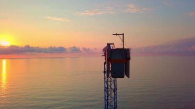 Gün batımında kuş bakışı bir vinç, güneş ışınları vinç yapısından geçer.